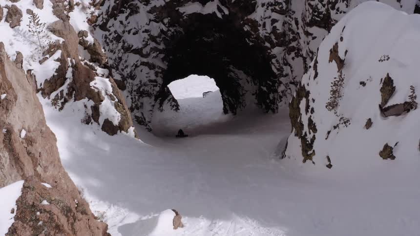 Person walking in a cave in a natural environment covered by snow