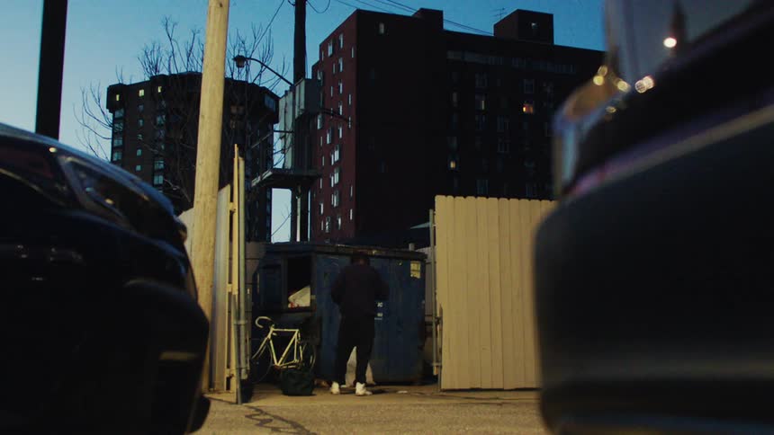 Man throwing his bike and bags in a corner across the city