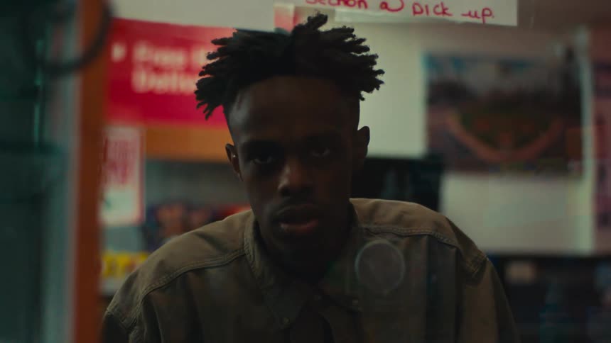 Portrait of a man in a store talking to another person and handing him a paper