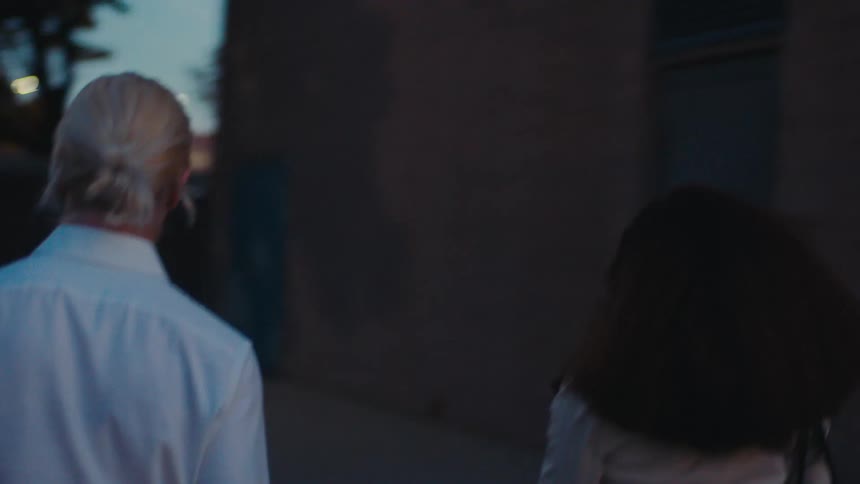 Man getting out of the car and walking next to a woman and entering an indoor space