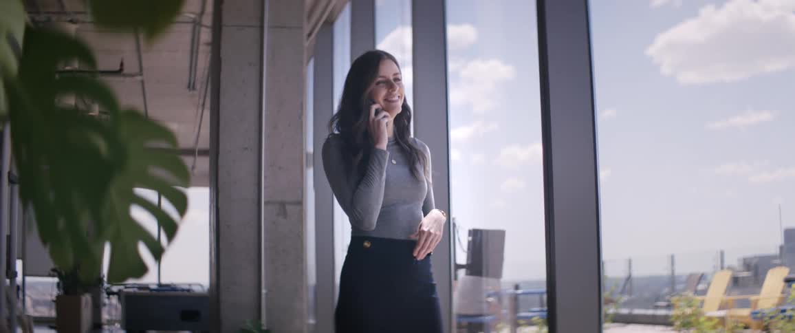 Woman in a modern office environment talking on a cell phone