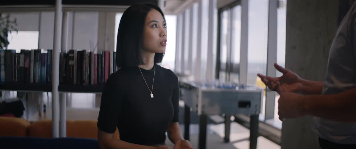 Portrait of a woman in a workspace talking to another person in front of her