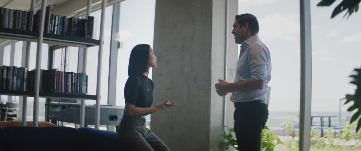 Two coworkers talk in the office lounge