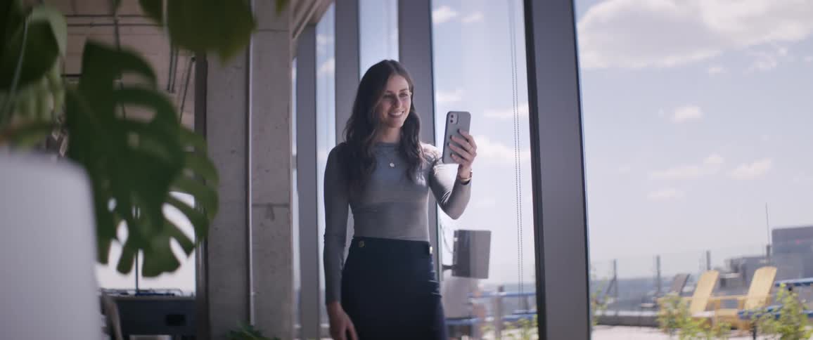 Woman in an office talking on selfie with her smartphone