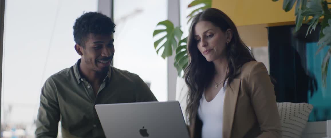 Coworkers consult laptop during a business discussion