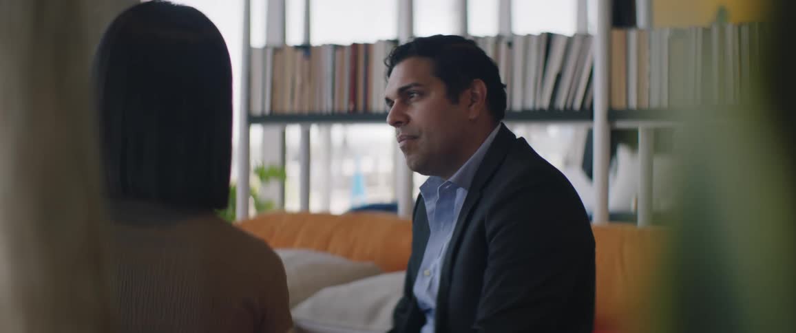 Concentrated man in a suit talking to a woman in a work environment