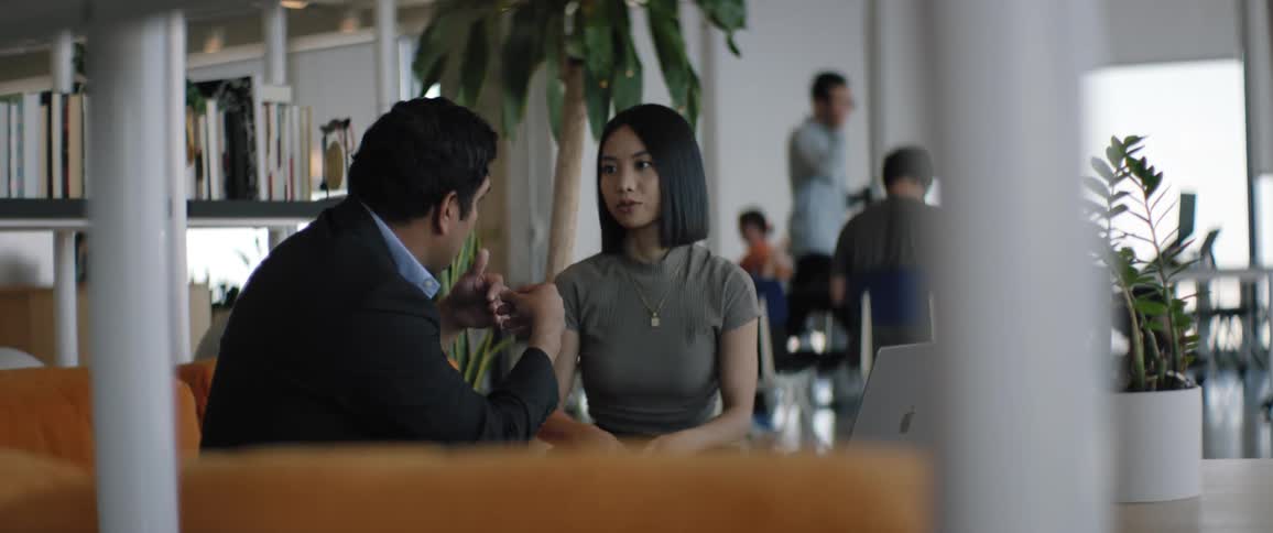 Coworkers talk in the office lounge
