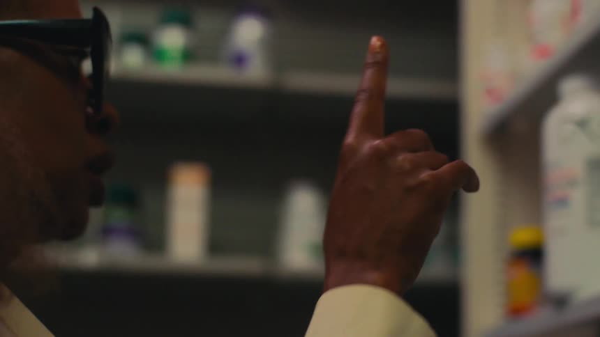 A pharmacist searches for a medication