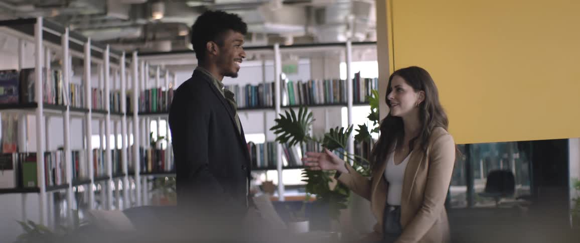 Two people in a modern office space engaged in a conversation