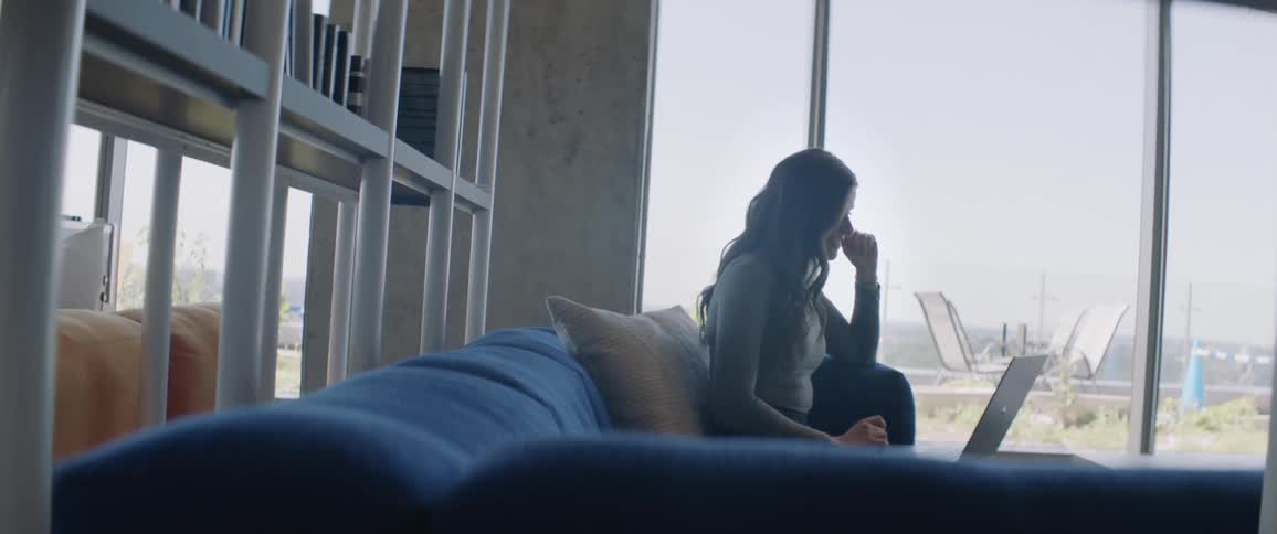 Woman sitting working on a laptop in a modern indoor environment
