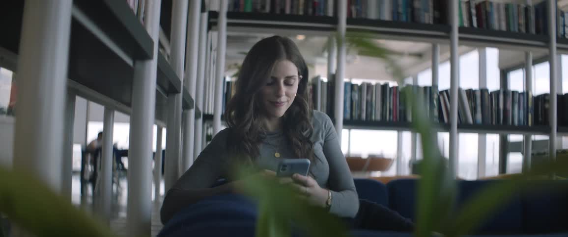Woman sitting on a blue sofa using her cell phone