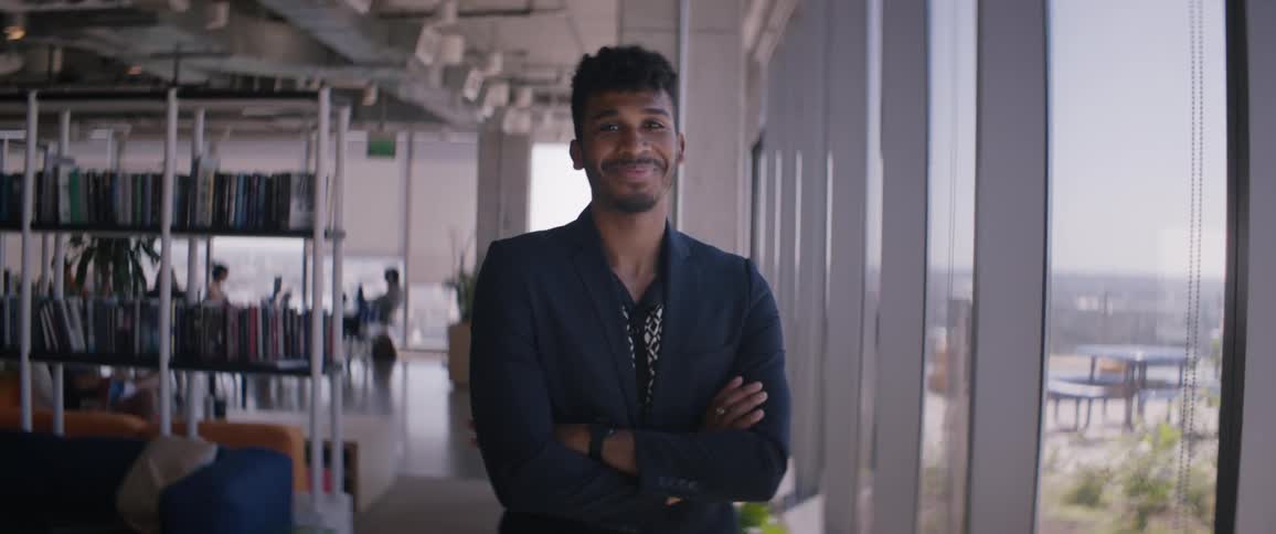 Portrait of a smiling man crossing his arms and wearing a blazer