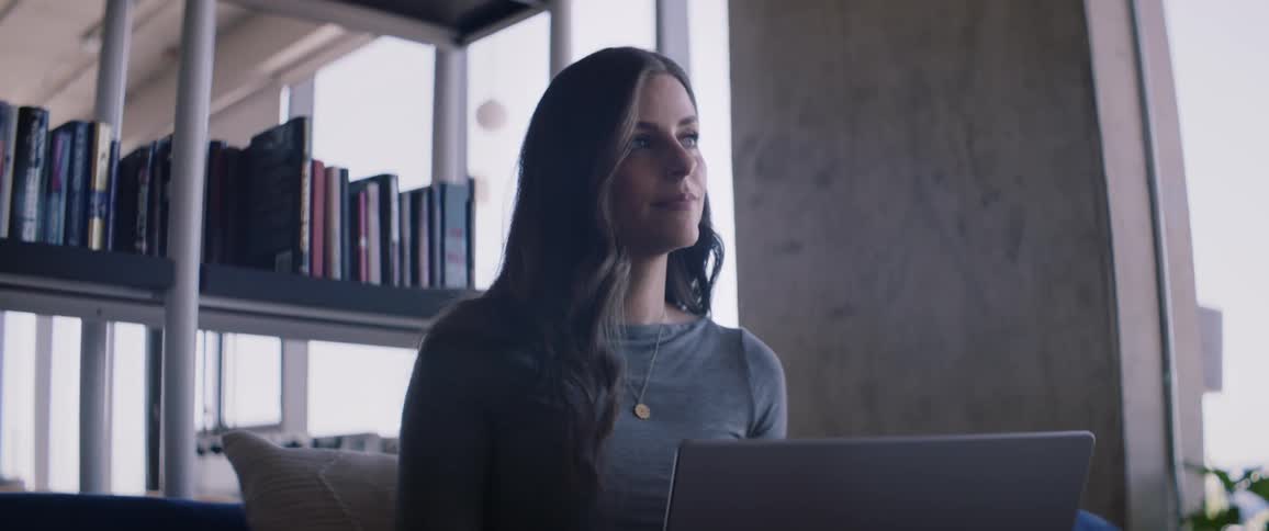 Woman sitting in front of a laptop in an office environment
