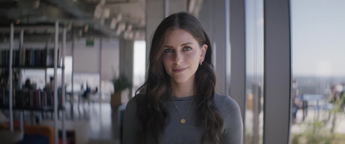Portrait of a young woman with light eyes smiling slightly while indoors