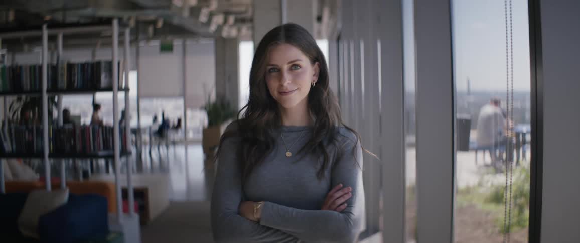 Portrait of a young woman crossing her arms while indoors