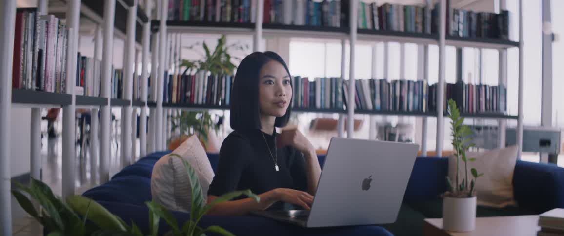 Woman sitting in an office environment working on a laptop