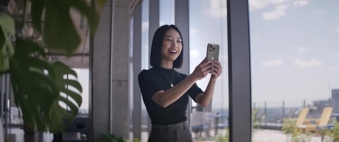 Woman next to mirrored windows talking in selfie with her cell phone and saying goodbye