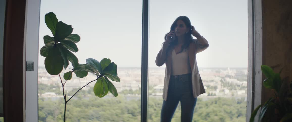 A woman makes a phone call while standing in an office