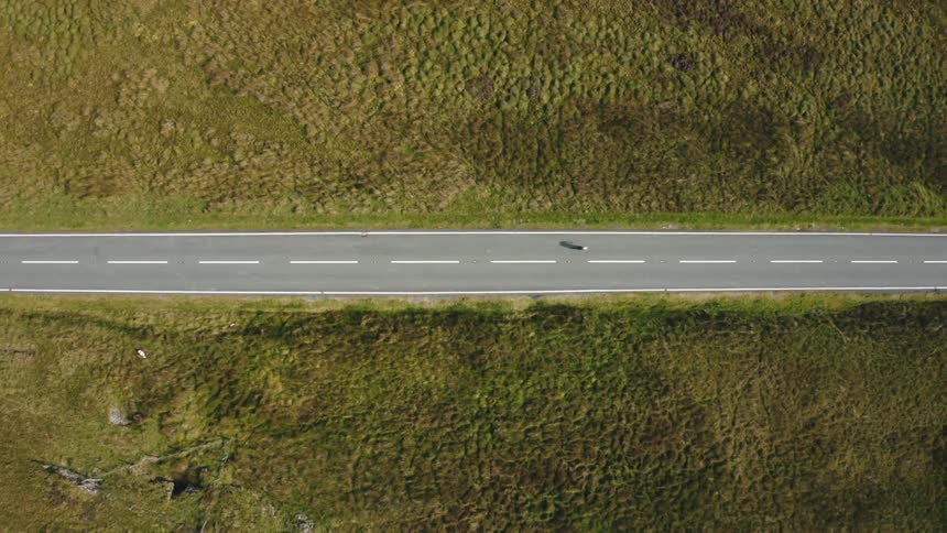 An empty remote road topdown drone of cyclist