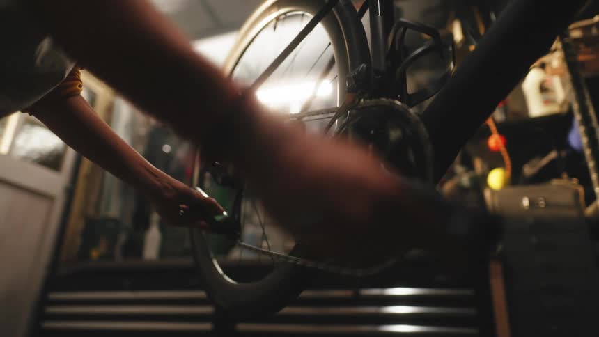 A close up clip of a person tuning and fixing a bicycle in workshop
