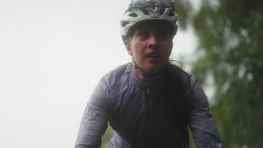 Portrait of a cyclist concentrated and making effort while pedaling on a cloudy day