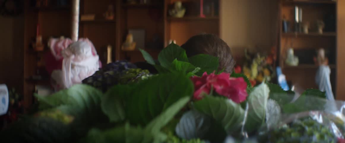 A man arranges flowers in his shop