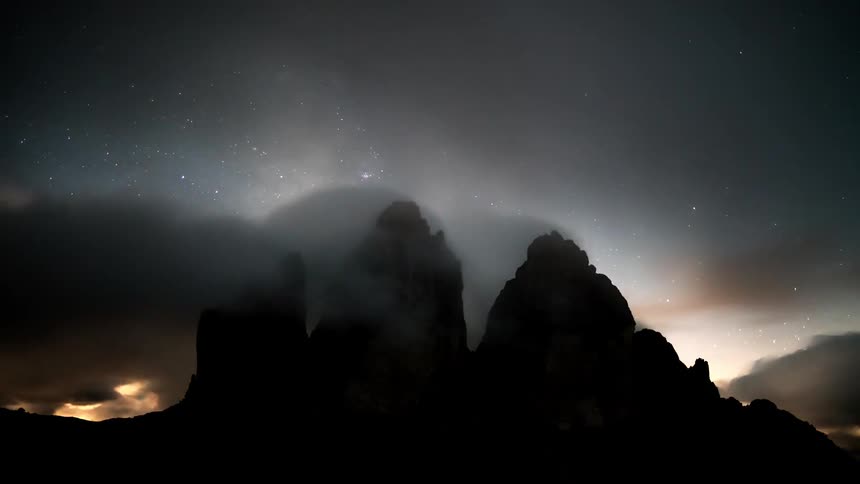 Night landscape with silhouettes of mountains and a starry sky