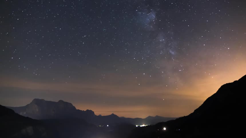 Lights flash on the mountain as the stars pass in the sky
