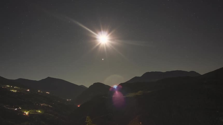 Mountain range and lights of vehicles passing by with the sun rising