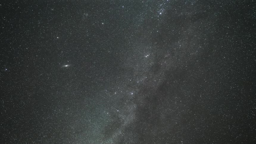 Shooting star flies through a night sky full of stars and a nebula