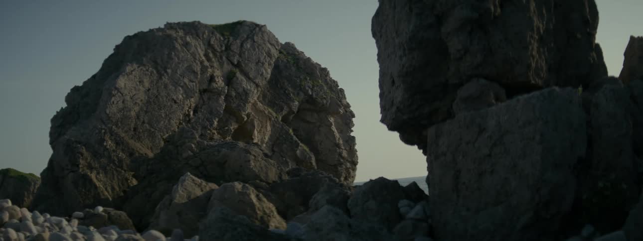 Rocks separate one rock formation from another containing a precariously balanced boulder