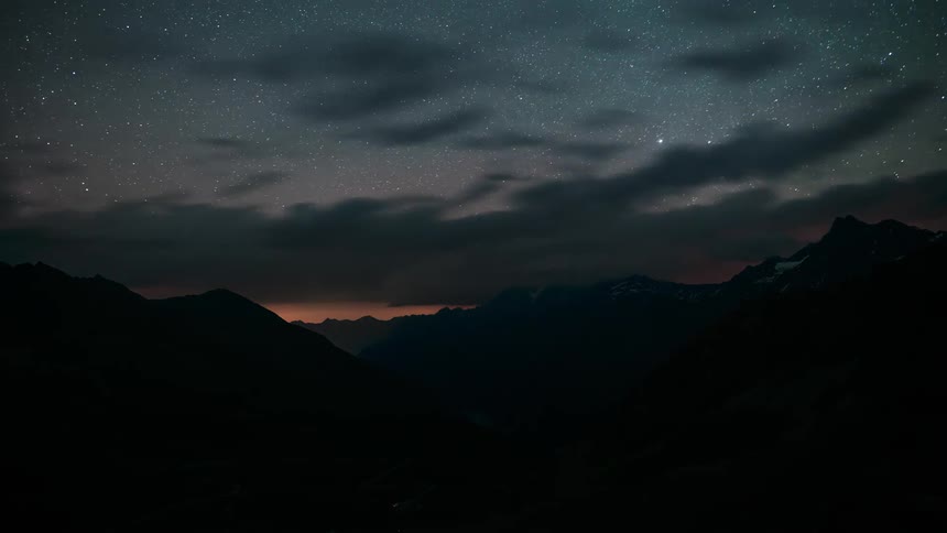 Mountainous landscape with the sky darkening and dawning in time lapse