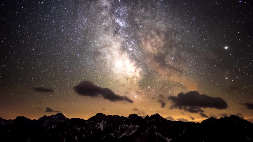 Silhouette of mountains with the dawning day and a starry sky