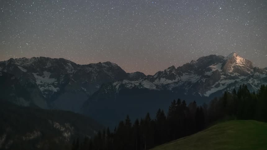 Night landscape with a starry sky over snowy mountains