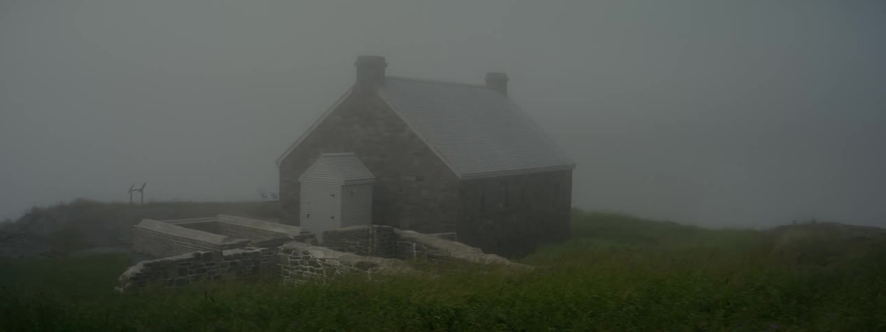 Isolated brick house on a hill on a cloudy and foggy day