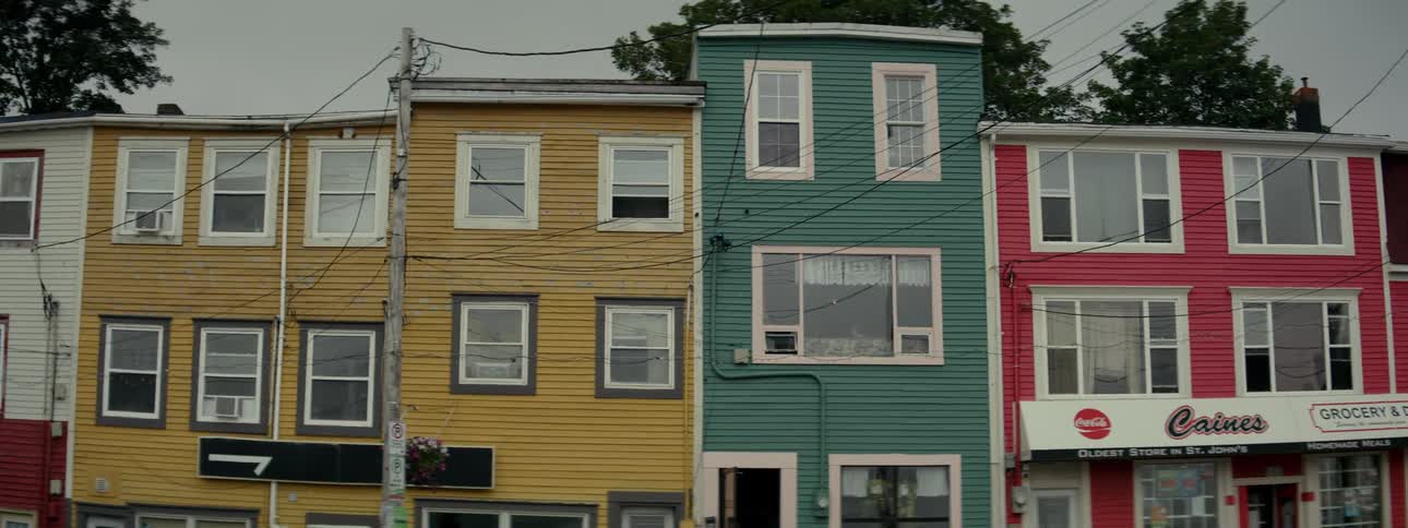 Multicolored apartment buildings are built next to a grocery store