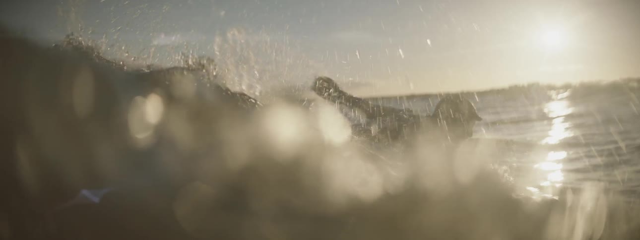 A man paddling a surfboard out into the waves on a clear day