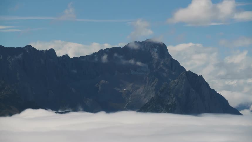 Time lapse of clouds rolling over steep mountain peaks