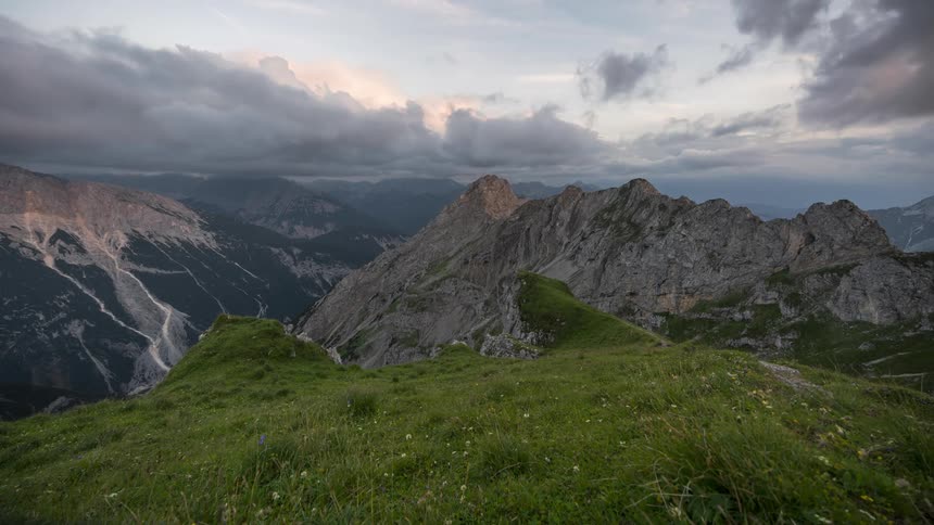 Time lapse of clouds forming over a mountainous landscape at dusk