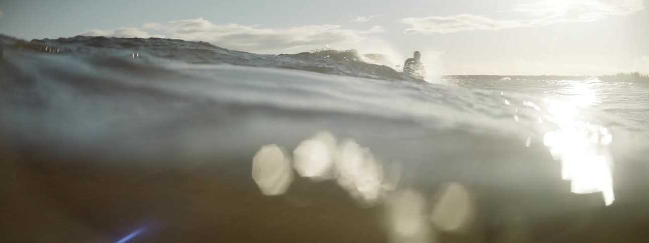 A surfer paddles and then attempts to stand on his board