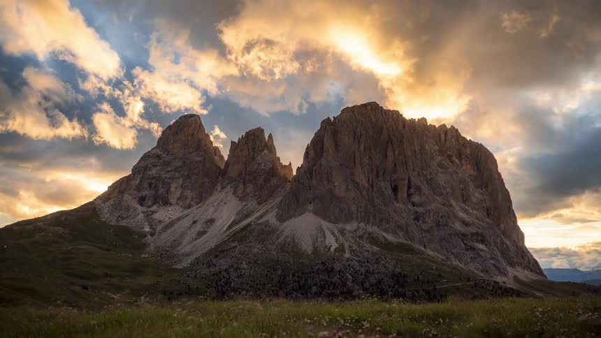 Big rocky mountains with the sun passing by in timelapse