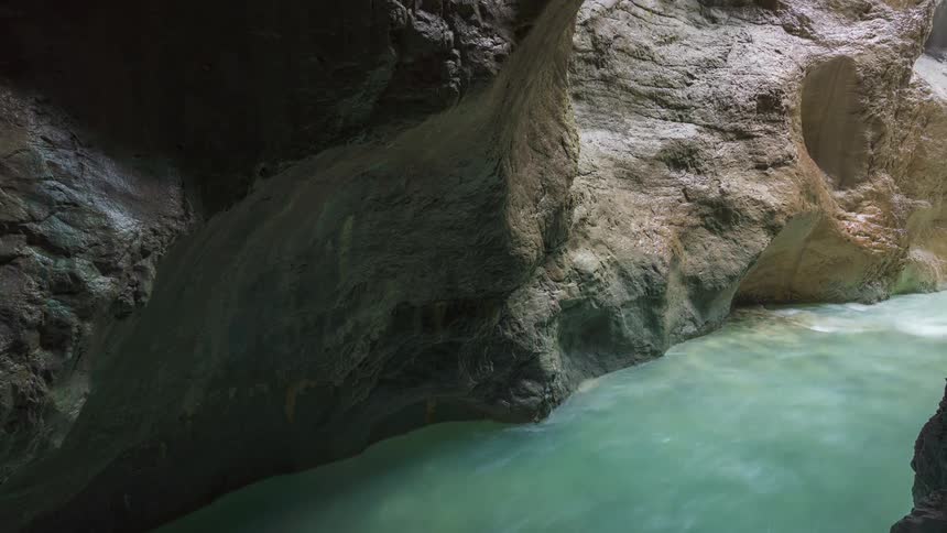 River of emerald green water flowing through a narrow canyon with rocky walls