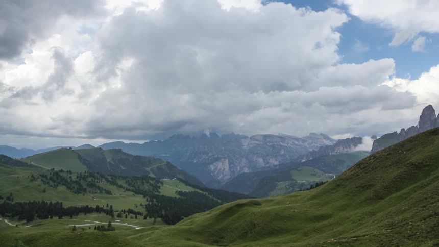 Landscape of green mountains under a cloudy sky with dense clouds