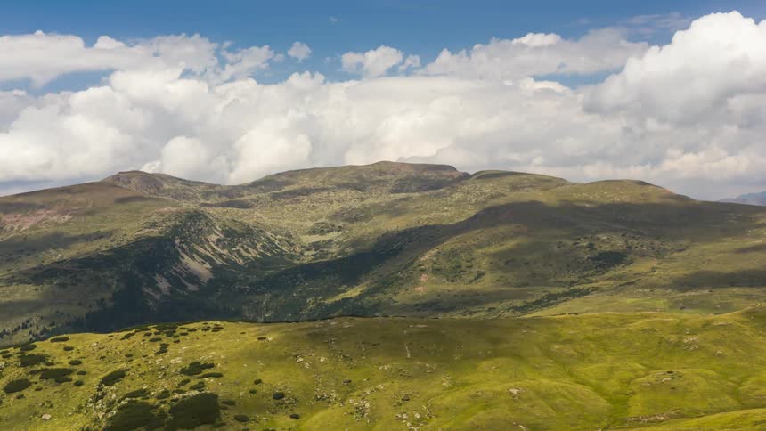 Greenish mountain with the shadow of clouds passing by
