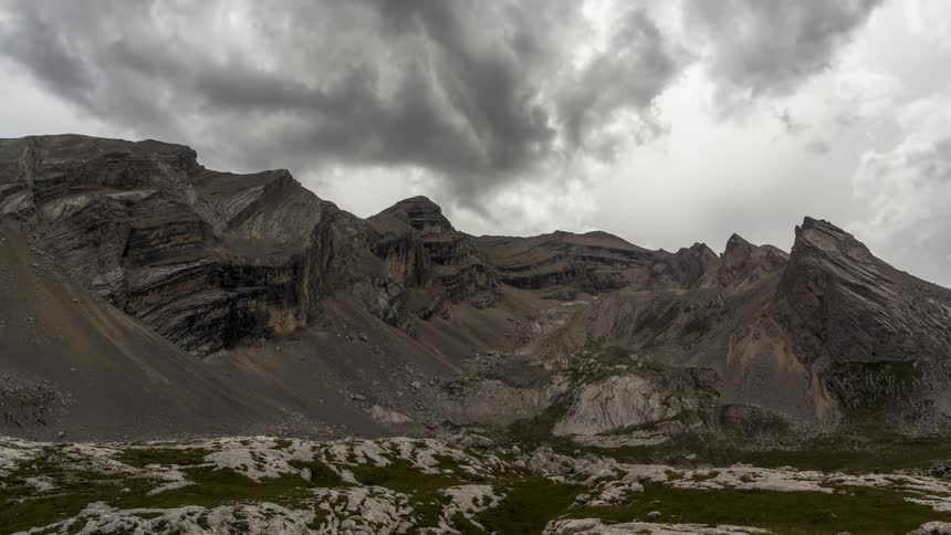 Clouds passing over mountain cast shadows on the land