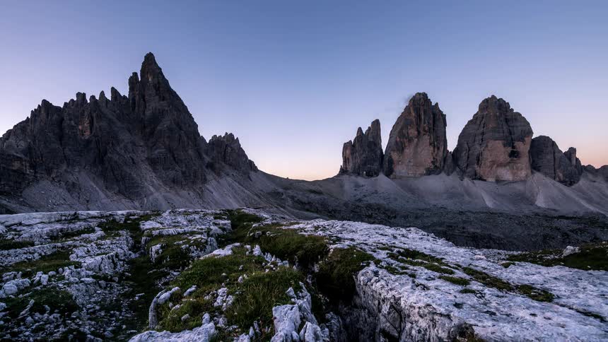 A mountainous region with snow on the ground and the day is passing and getting brighter