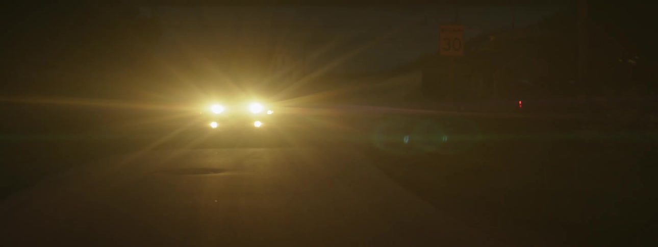 Headlights of a car on at night while moving