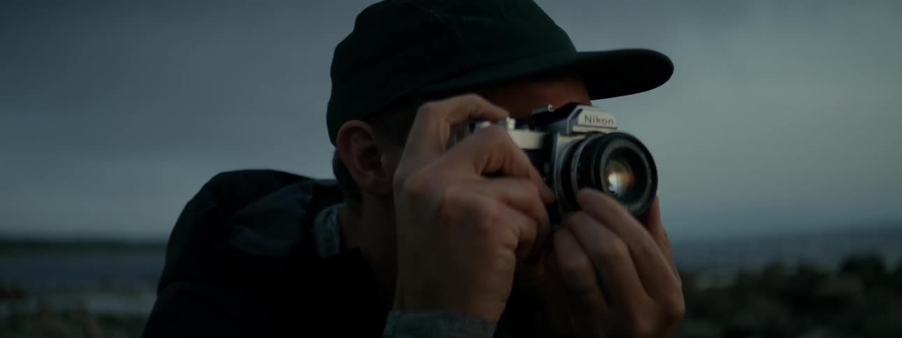 Portrait of a photographer using his camera in a natural environment on a cloudy day
