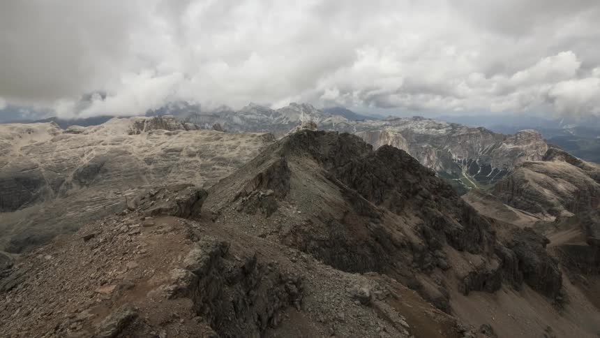 Rocky mountain range with tourists hiking on a cloudy day
