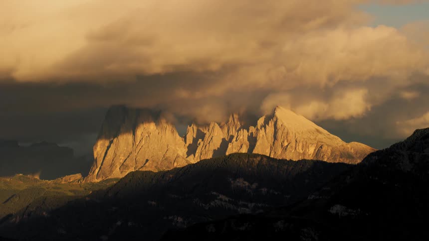 Time lapse of clouds rolling over a steep mountain range